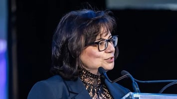 Soula Chronopoulos speaking at a podium