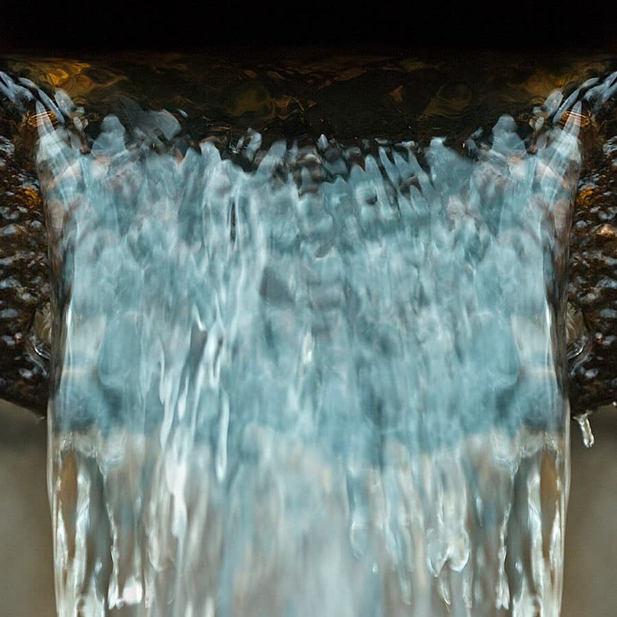 Close-up of clear water cascading smoothly over a ledge.