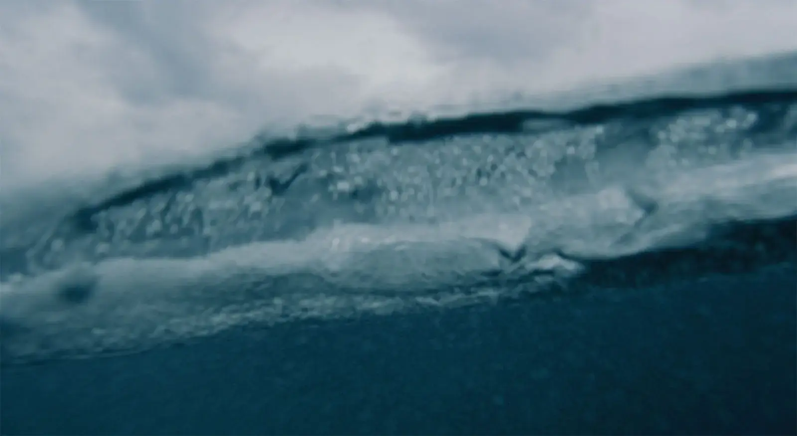 Blurry underwater view with light refracting through turbulent waters.
